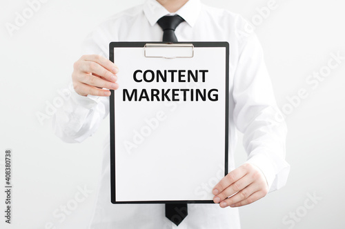 Text content marketing on a tablet in the hands of a businessman on a gray isolated background photo