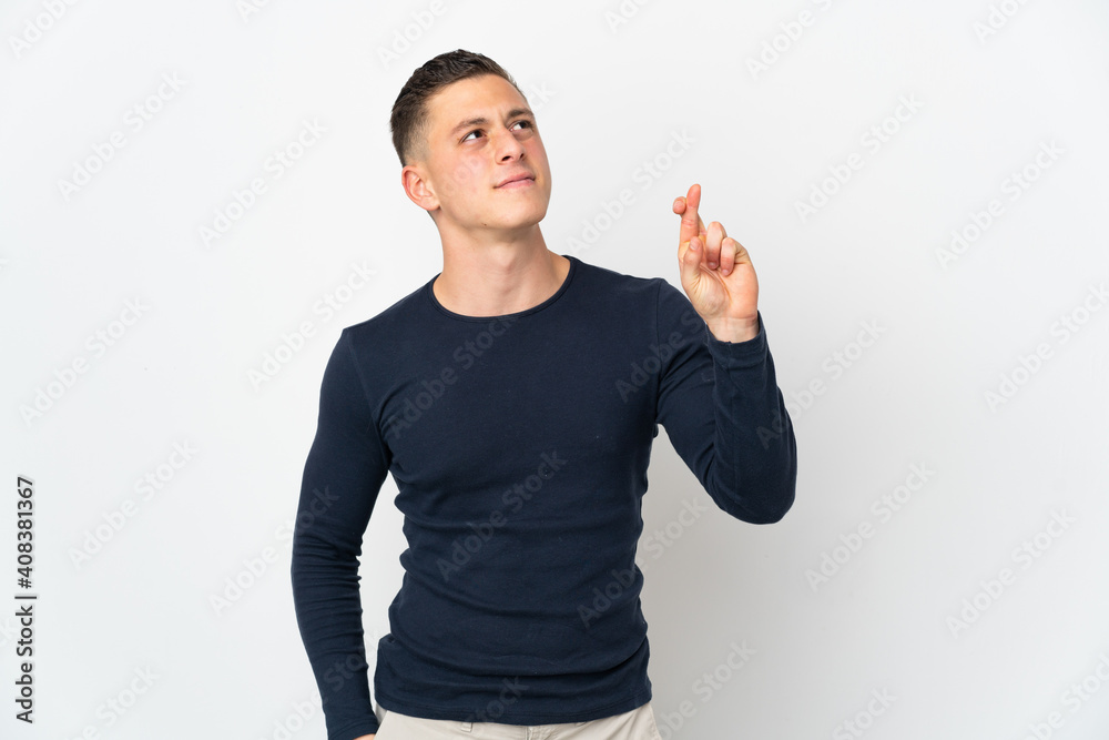 Young caucasian man isolated on white background with fingers crossing and wishing the best Young caucasian man isolated on white background with fingers crossing and wishing the best