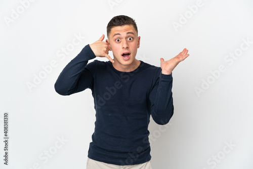 Young caucasian man isolated on white background making phone gesture and doubting