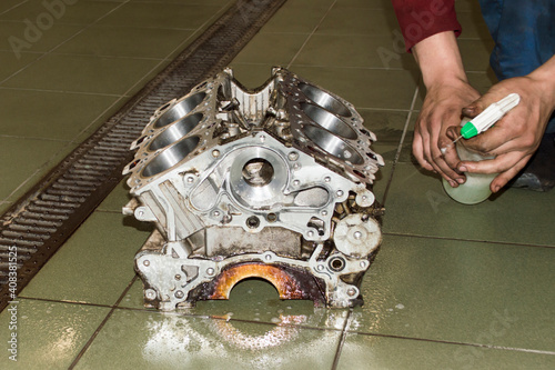 Принти на полотні The mechanic applies detergent to the engine cylinder block