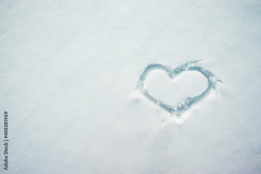 Handwritten heart on snow surface. Symbol of love, romance, Valentine's Day.