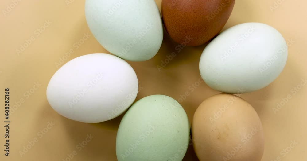 Naturally colored eggs rotating on a beige background. Naturally colored eggs rotating on a beige background.