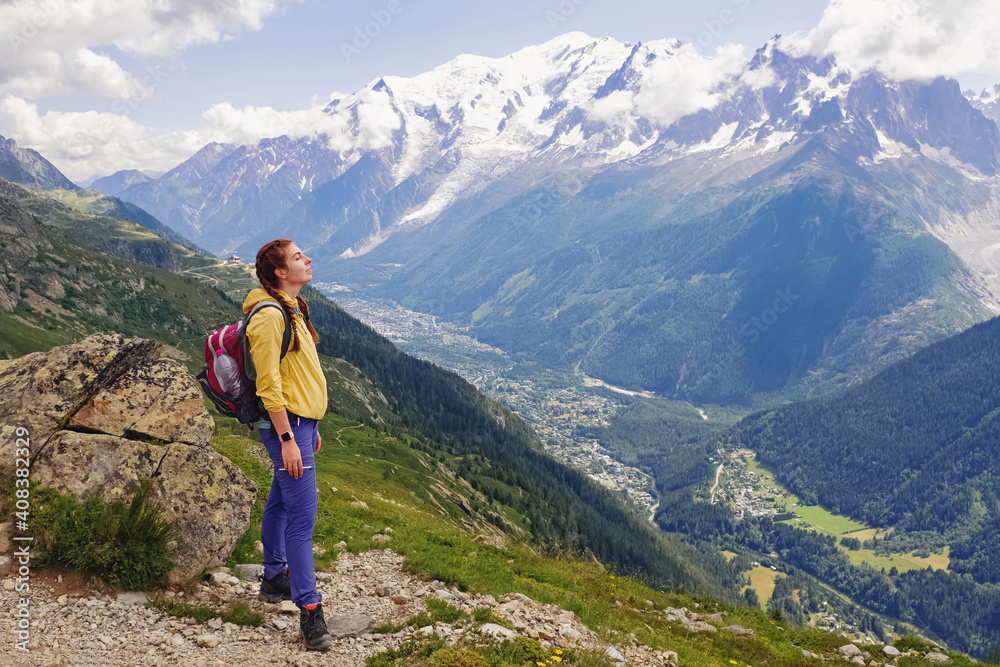 Young woman with backpack hiking in mountains
