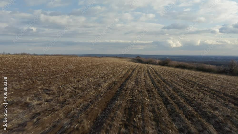 Agricultural field plowed brown soil drone flying over view at low altitude
