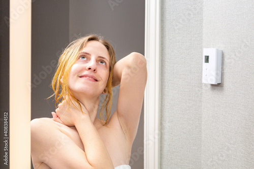 Beautiful young woman smiling happily and relaxing after shower in the bathroom. Concept about lifestyle and people.