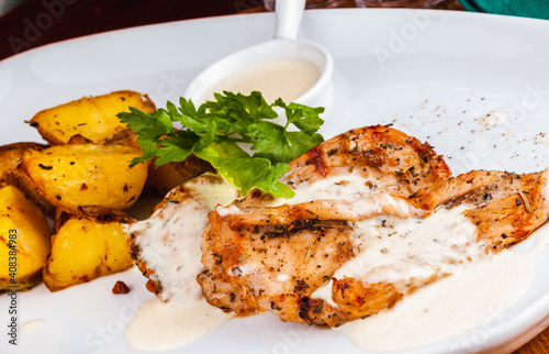 Grilled meat steak and baked potato on white plate.