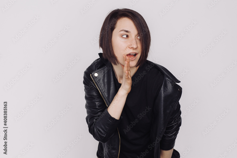 Portrait of surprised female in a black sweater and black jacket isolated on white background. Portrait of surprised female in a black sweater and black jacket isolated on white background.
