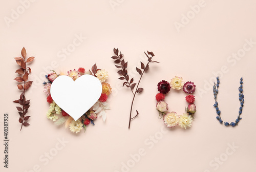 Phrase I Love You made of flowers and paper heart on beige background, flat lay