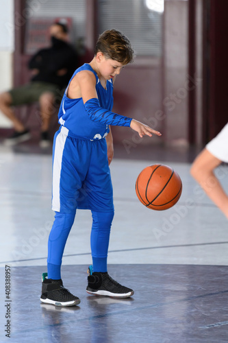 Young athletic boy playing in a game of basketball
