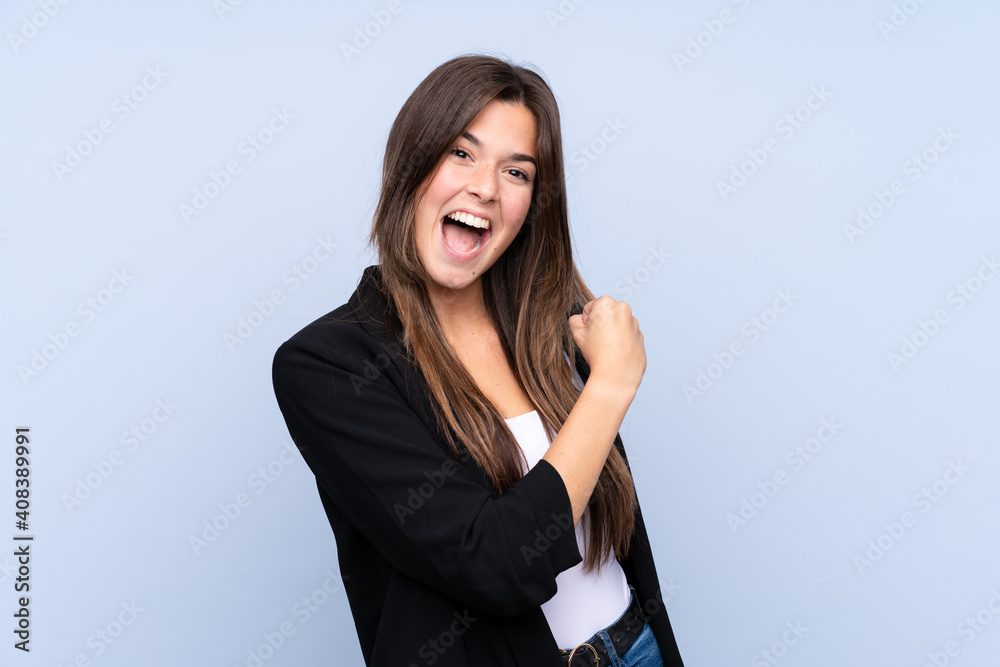 Young Brazilian business woman over isolated blue background celebrating a victory