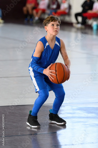 Young athletic boy playing in a game of basketball © Joe
