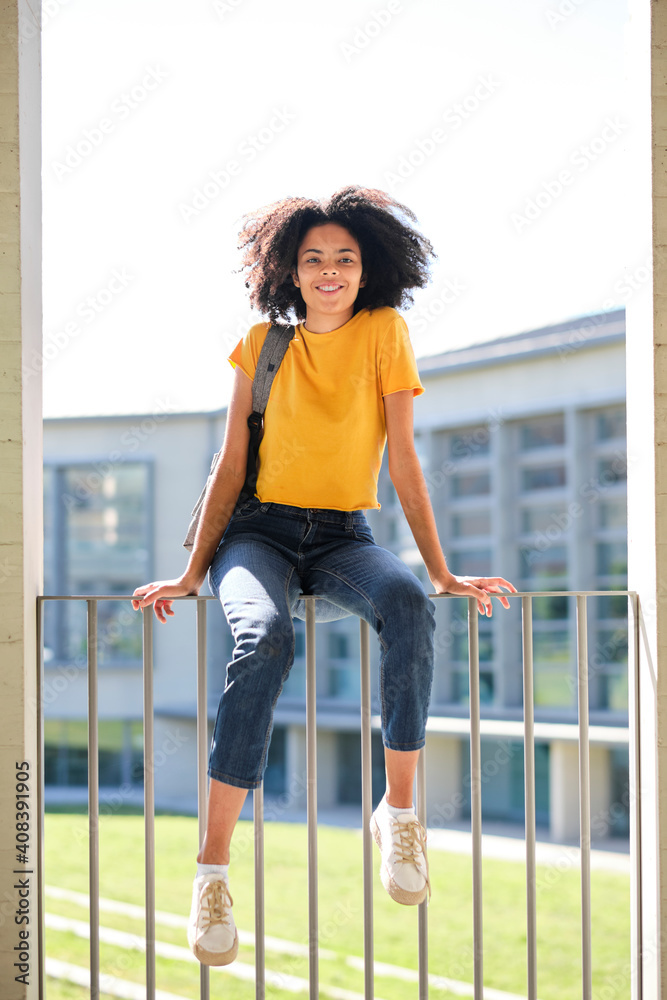 Smiling woman sitting on railing at university Smiling woman sitting on railing at university