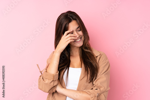 Teenager Brazilian girl over isolated pink background laughing
