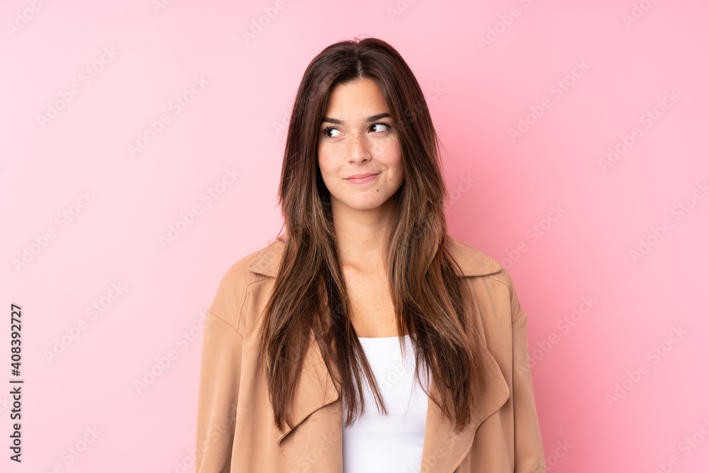 Teenager Brazilian girl over isolated pink background standing and looking to the side