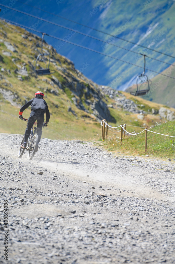 Extreem outdoor sport challenge in French Alps mountains in summer, riding downhill on sport bike on special bicycle path