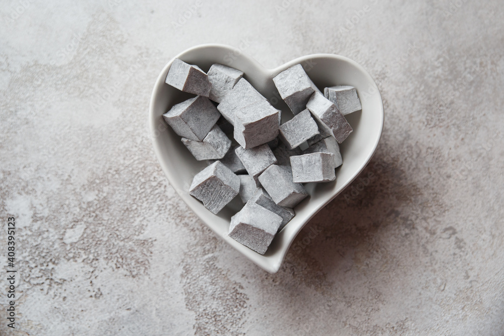 Turkish delight. Turkish sweets in a heart-shaped plate. lokum.Grey colour. Valentine's day concept. Background image for design Turkish delight. Turkish sweets in a heart-shaped plate. lokum.Grey colour. Valentine's day concept. Background image for design