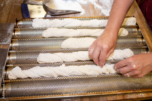Bread baking process. Woman working with dough. forming a baguette - French roll