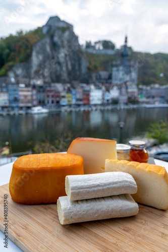 Cheese collection, Belgian abbey cheeses made with brown trappist beer and fine herbs and view on Maas river in Dinant, Wallonia, Belgium photo