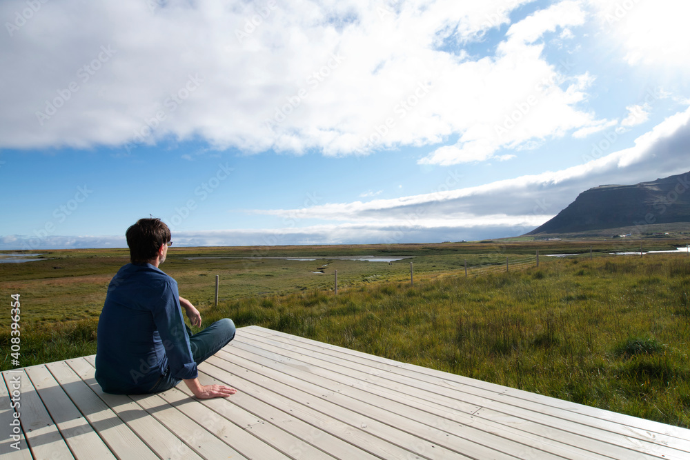 Man looking at view while sitting on terrace at Flokalundur, Iceland