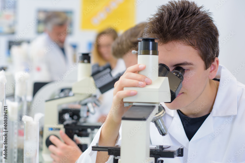 young man and a microscope young man and a microscope