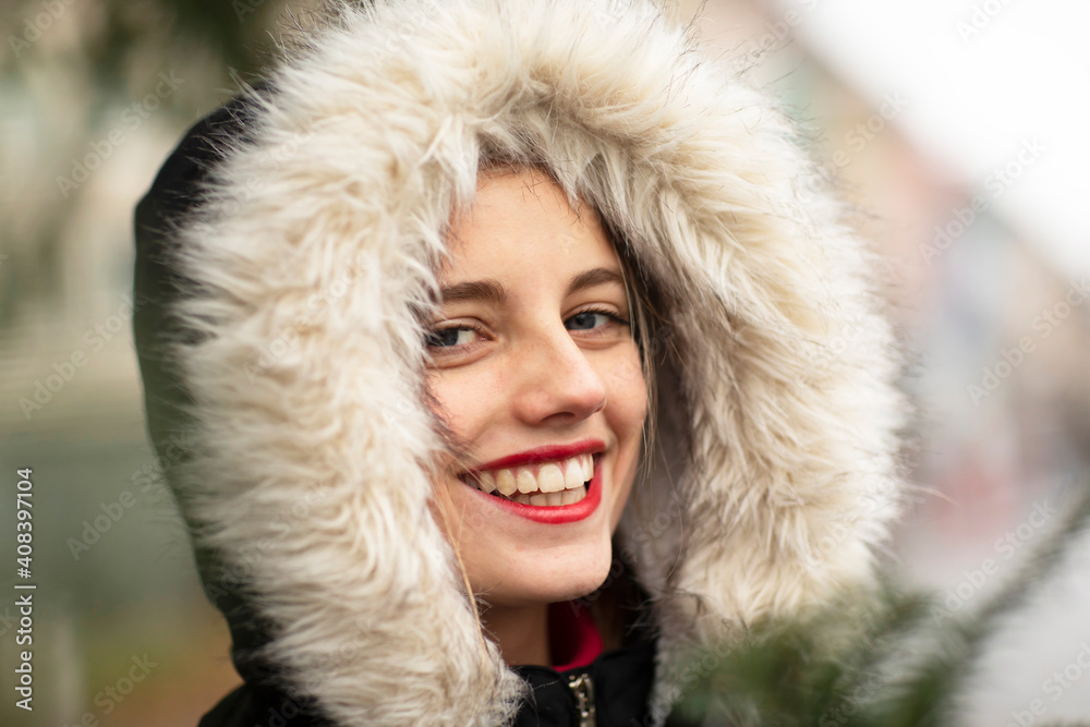 Happy young woman wearing jacket with fur during Christmas Happy young woman wearing jacket with fur during Christmas