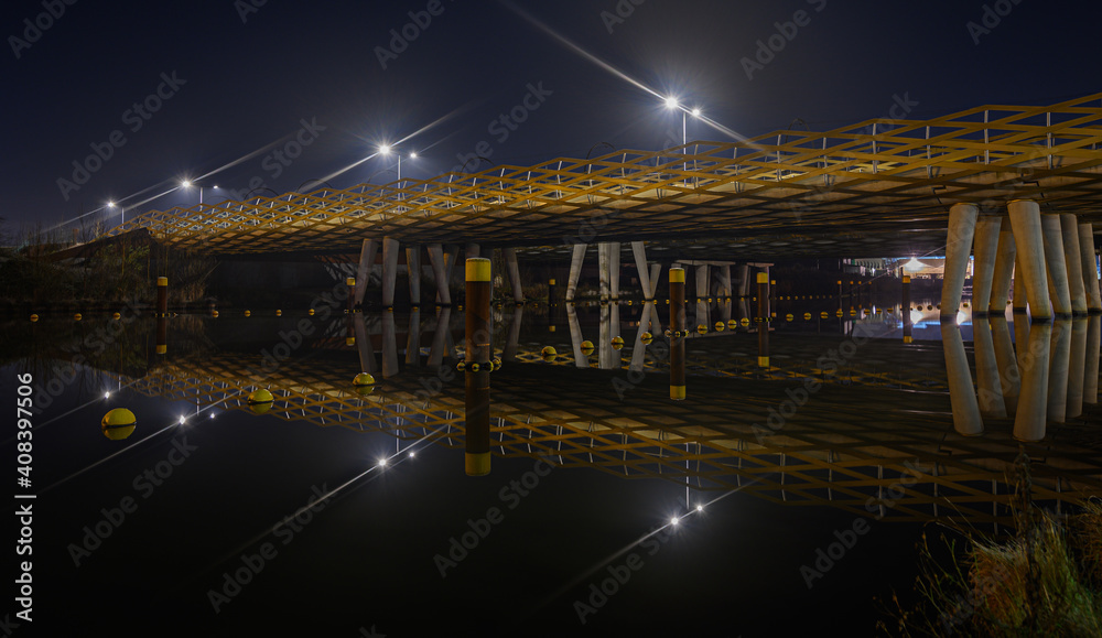 Long exposure shot of an pedestrian bridge reflected in the night