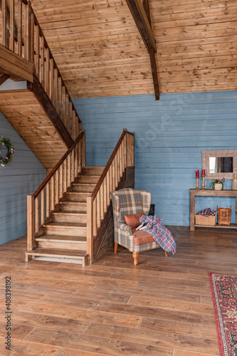 cozy all wooden interior of a country house in a wooden design. spacious living room with kitchen area with large windows. bedroom on the second floor. photo