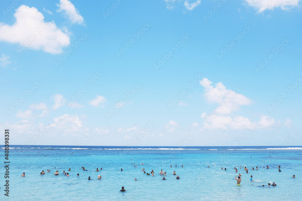 People enjoying calm blue water at the beach People enjoying calm blue water at the beach