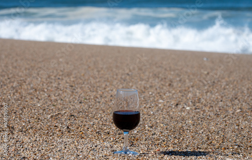 Tasting of different fortified dessert ruby, tawny port wines in glasses on sandy beach with view on waves of Atlantic ocean near Vila Nova de Gaia and city of Porto, Portugal photo