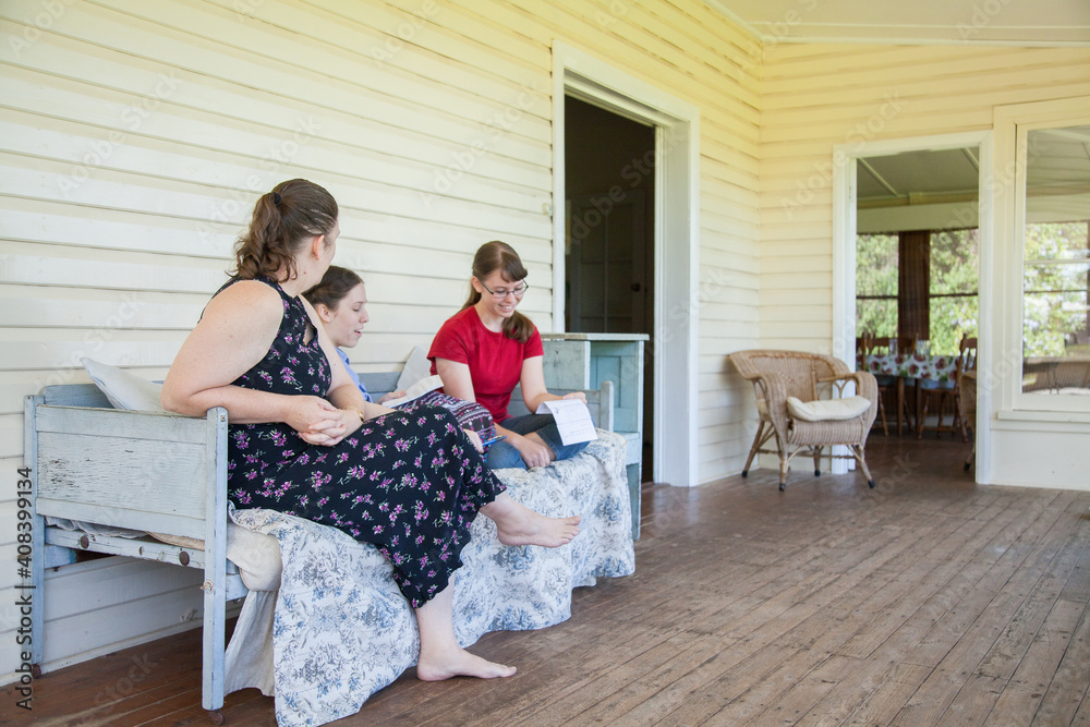 Mum and two daughters talking together on the verandah Mum and two daughters talking together on the verandah
