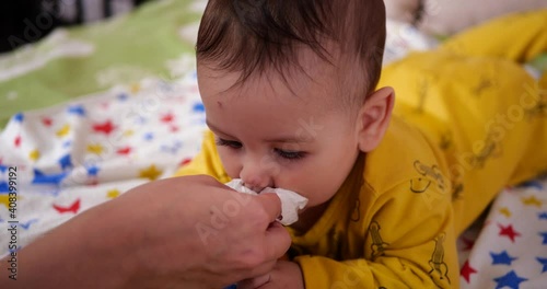 Family concept. Mother is wiping the snot on the baby. young mom wipes drool. 4k Resolution