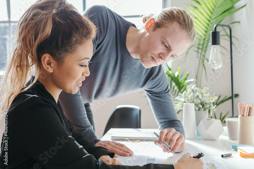 Female worker explaining something to a male team member