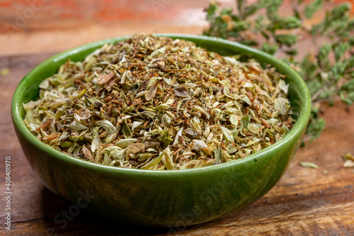 Dried aromatic kitchen herb oregano in green bowl