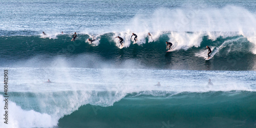 Group of surfers on a wave photo