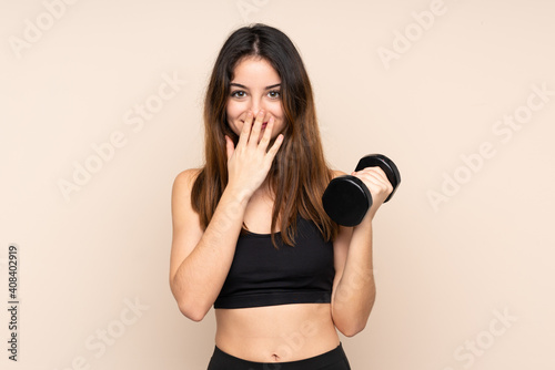 Young sport woman making weightlifting isolated on beige background with surprise facial expression