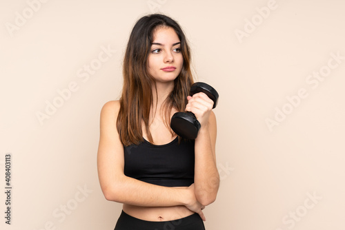 Young sport woman making weightlifting isolated on beige background thinking an idea