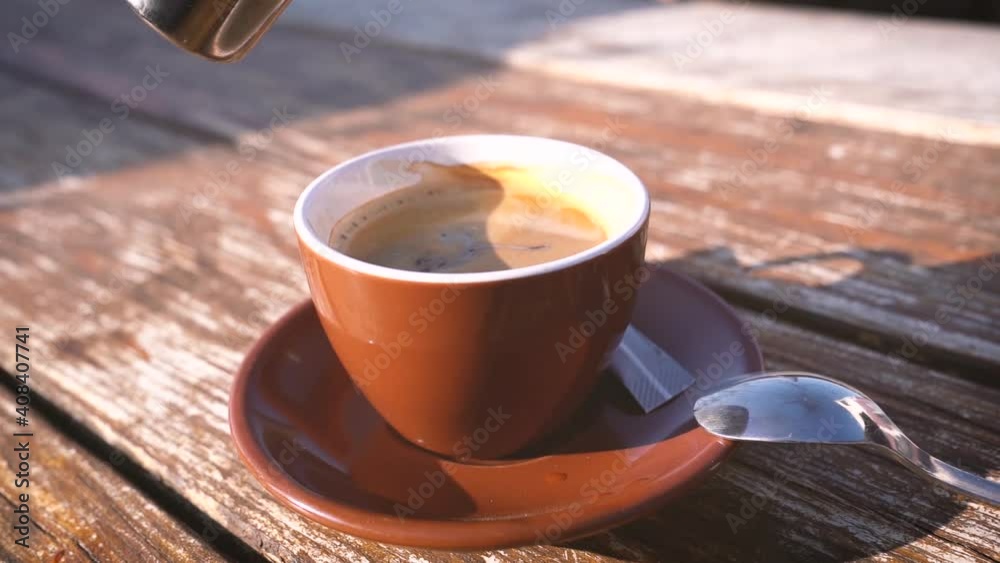 Milch in eine Tasse Kaffee eingießen