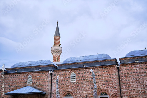 Details of Dzhumaya Mosque and its minaret extends to cloudy sky background. photo