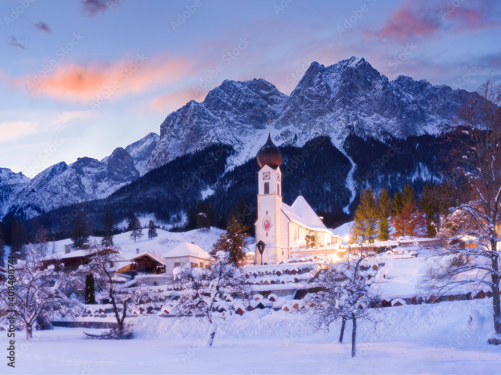 winter sunrise behind beautiful church in the mountains - Grainau village, Bavaria