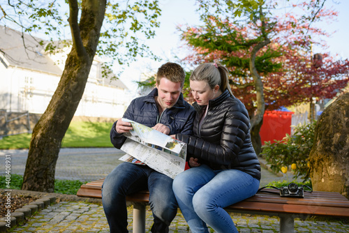 Couple reading paper map in city photo