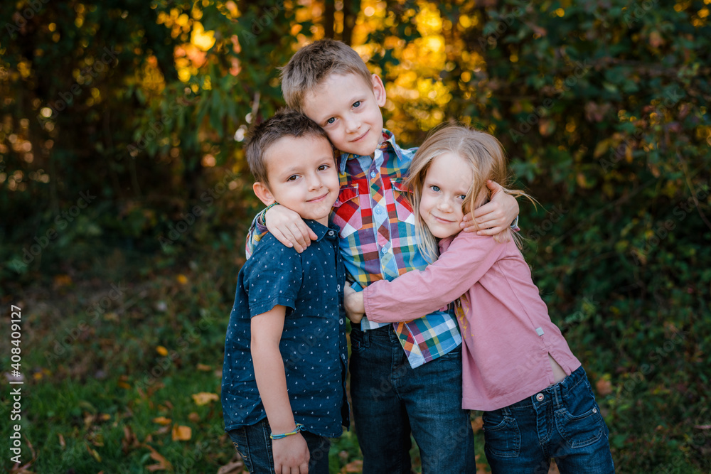 brothers and sister embracing outdoor family portrait brothers and sister embracing outdoor family portrait