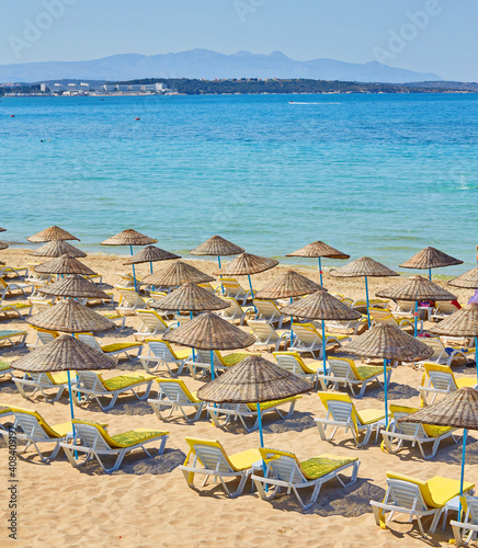 Empty sunbeds on ilica beach by the open sea, Cesme photo