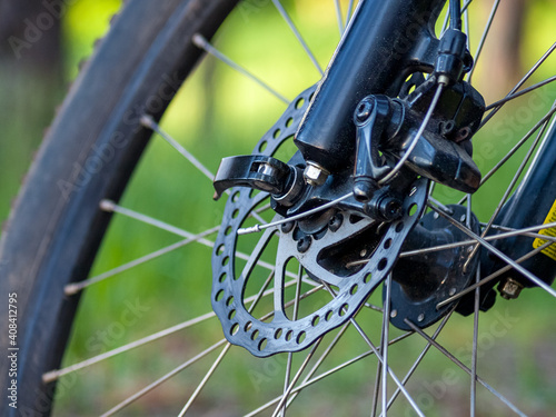 high-speed bicycle disc brake system, perforated disc and caliper, mtb, close-up, mountain bike brake efficiency