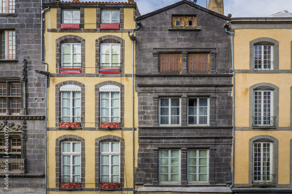 typical facades built with volcanic stones in the clock tower street (Rue de l'horloge), in Riom, a small town in Auvergne (France)