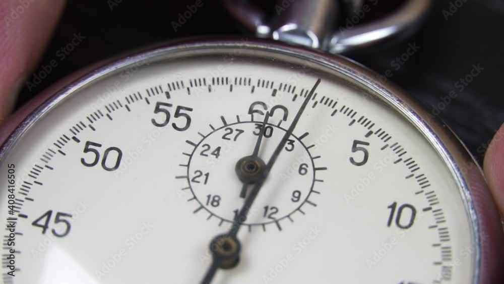 A stopwatch on a dark wooden table. A tool for measuring time. Macro photography. An old vintage stopwatch, the hand is moving. A stopwatch on a dark wooden table. A tool for measuring time. Macro photography. An old vintage stopwatch, the hand is moving.