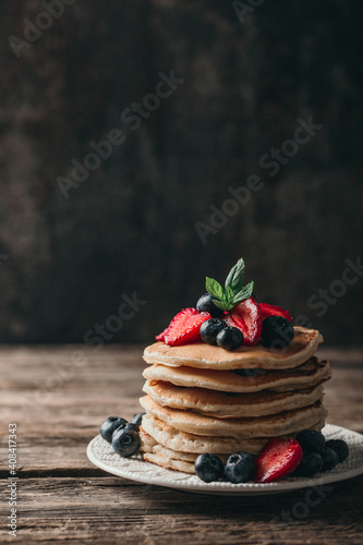 American pancakes with fresh berry on wood background. Summer homemade breakfast.