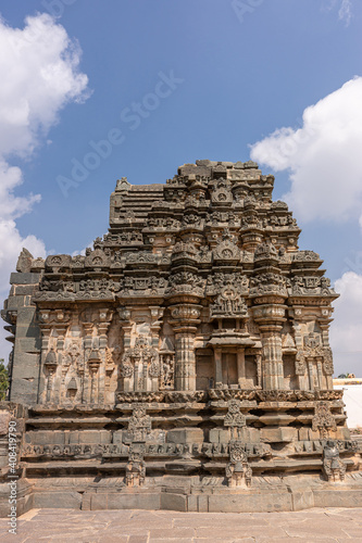 Lakkundi, Karnataka, India - November 6, 2013: Kasivisvesvara Temple. Closeup of brown stone sanctum under blue cloudscape.