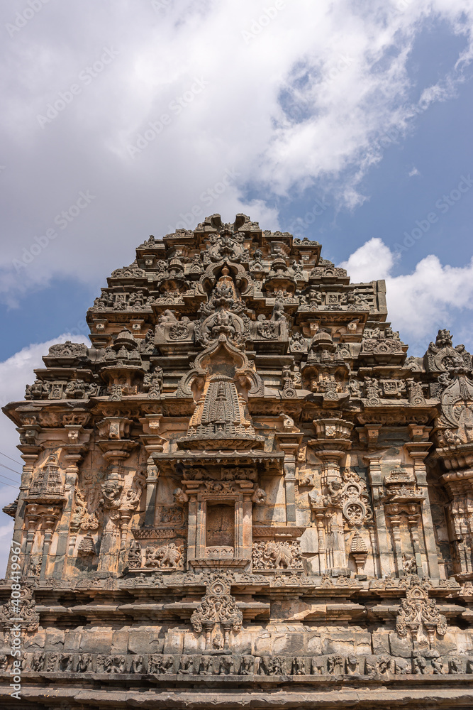 Lakkundi, Karnataka, India - November 6, 2013: Kasivisvesvara Temple. Brown stone top of vimanam under heavy blue cloudscape. 