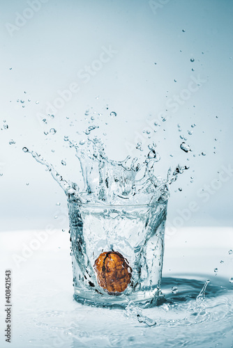 a walnut splashing in a glass of water