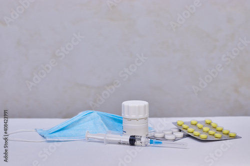Syringe, pills and facemask. Preventive vaccination of people. Treatment of disease.